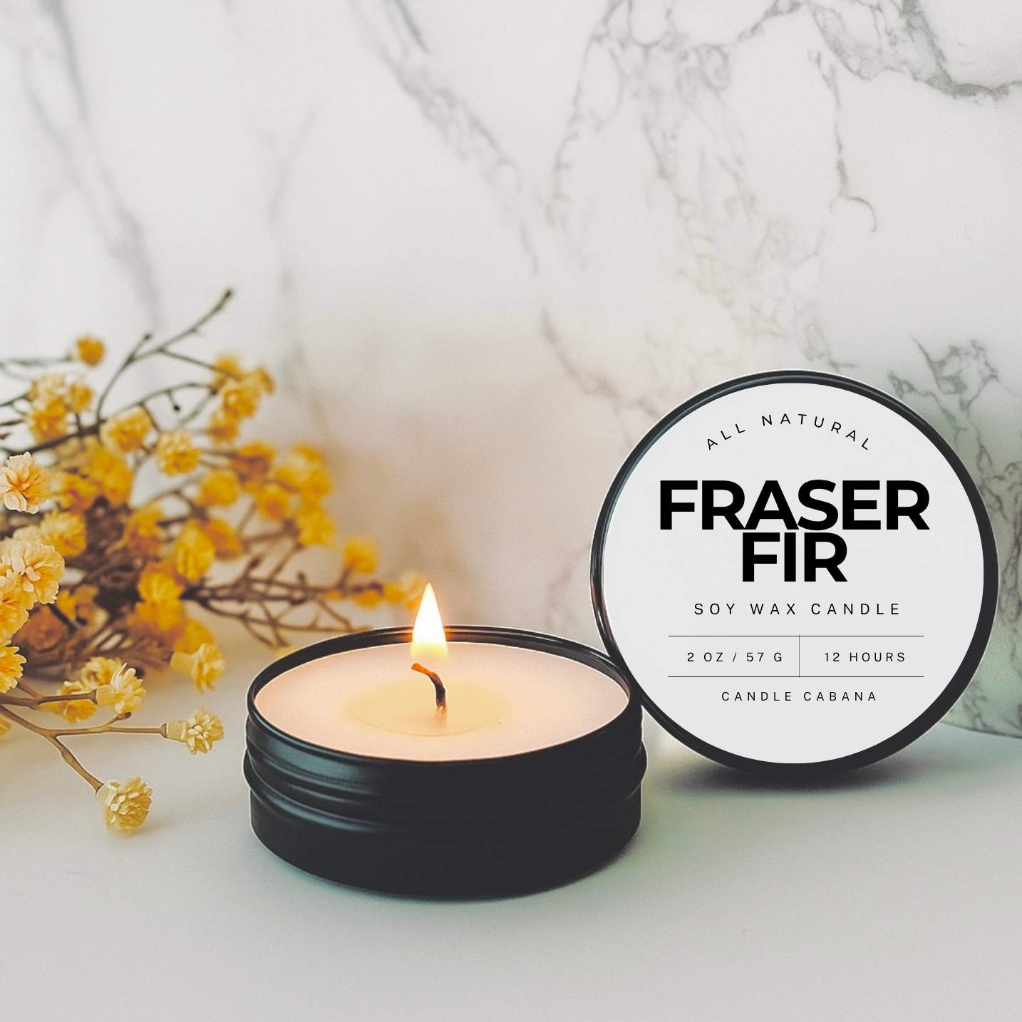 All natural Fraser Fir soy wax candle in a black tin with a label, surrounded by yellow flowers on a marble surface.